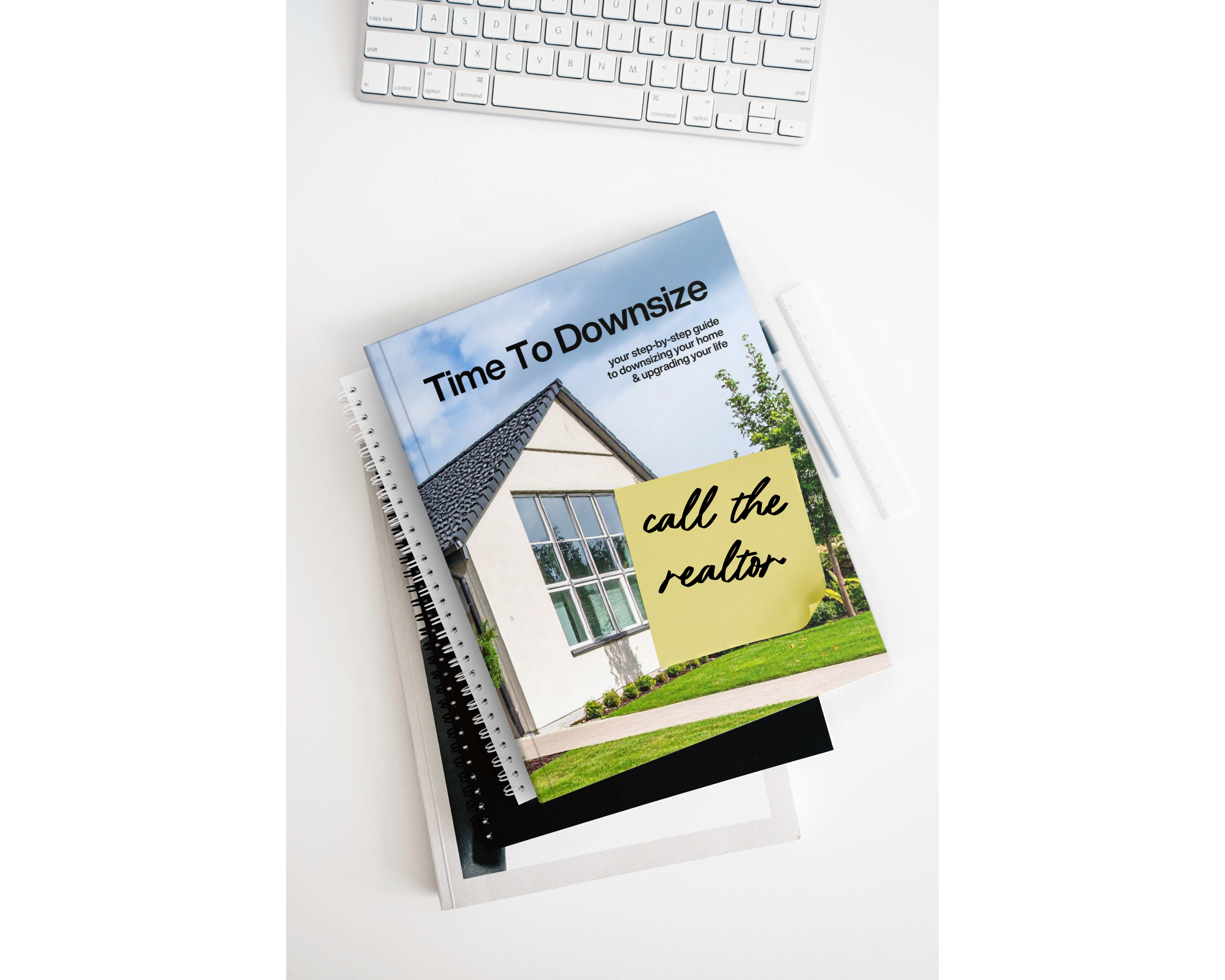 Book titled 'Time To Downsize: Call the Realtor' on a white surface with a keyboard. elevated agent